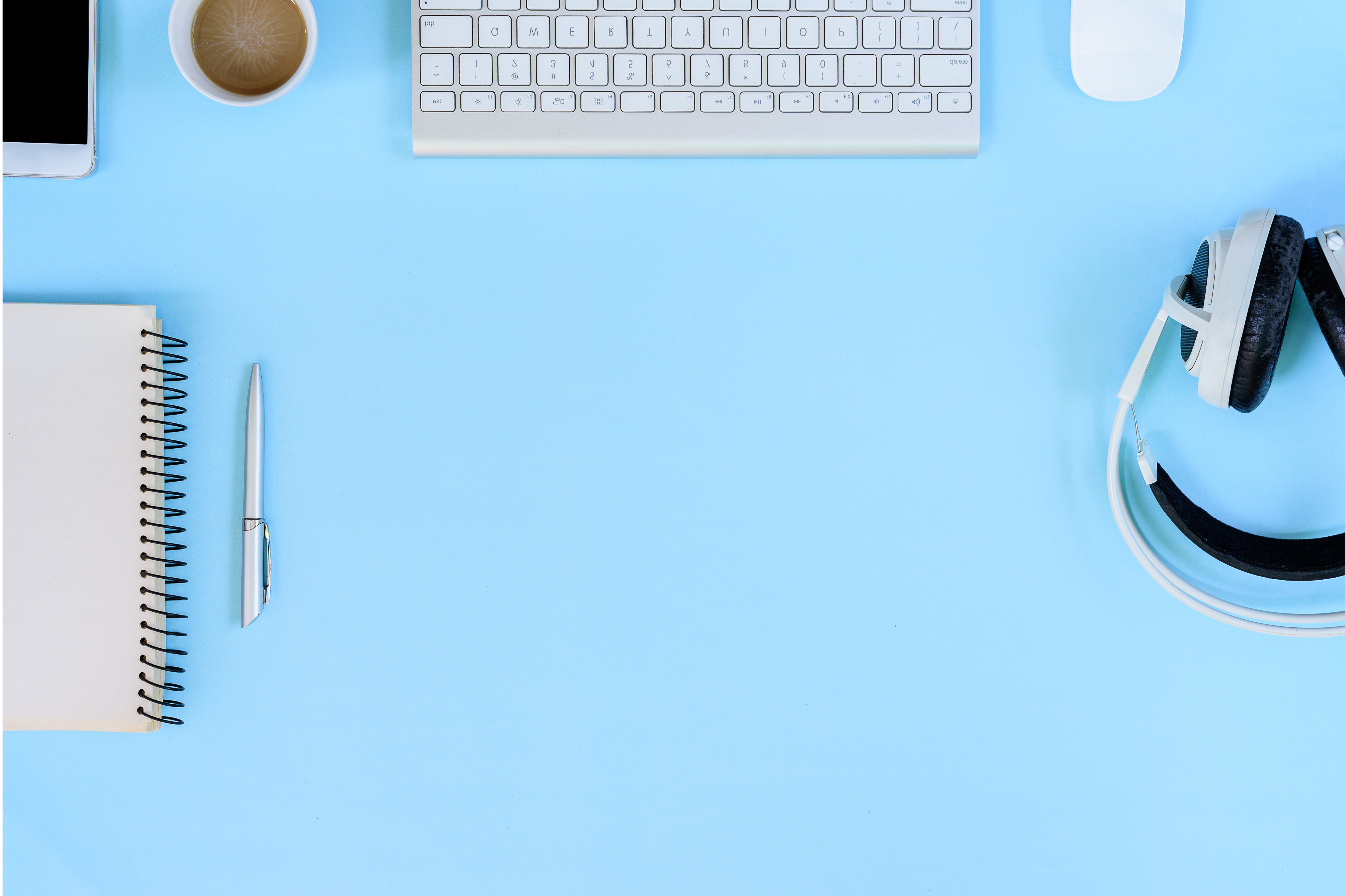 A blue table seen from above with SaaS tools on top like headphones, keyboard, laptop, smartphone etc.